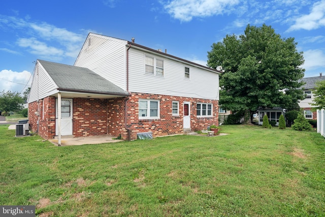 rear view of house featuring a lawn, central AC, and a patio