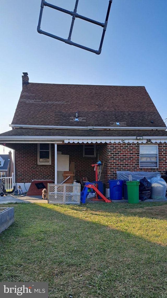 rear view of property featuring a yard