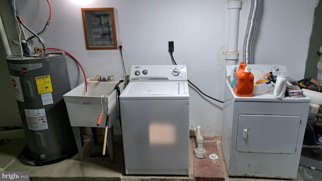 clothes washing area featuring water heater, sink, and independent washer and dryer