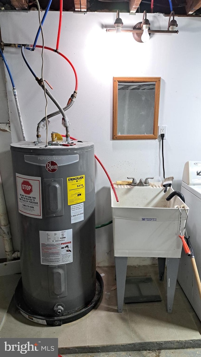 utility room with electric water heater and washer / clothes dryer