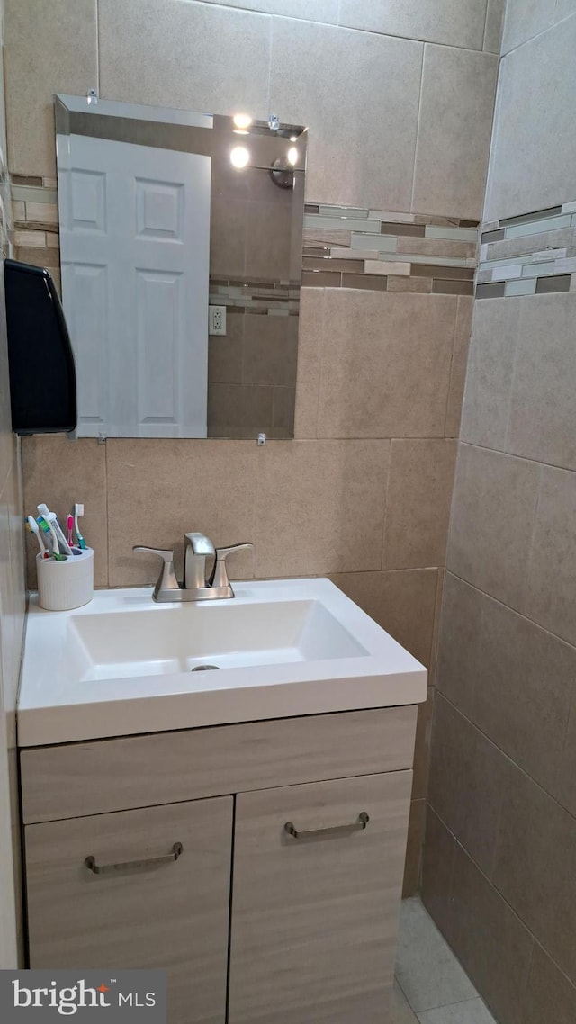 bathroom with backsplash, vanity, and tile walls