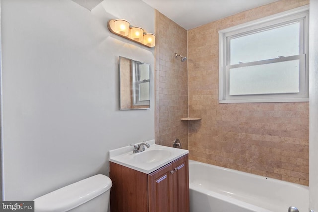 full bathroom featuring tiled shower / bath, vanity, and toilet