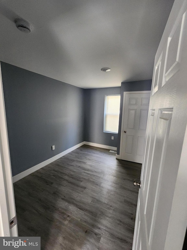 empty room featuring dark hardwood / wood-style flooring