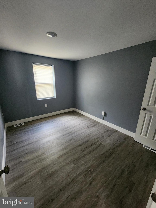 empty room with dark hardwood / wood-style flooring