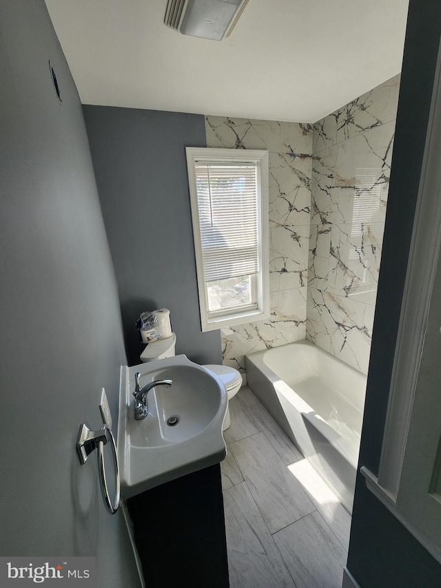 bathroom with vanity, toilet, and tile walls