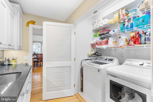 washroom with light hardwood / wood-style floors and washing machine and dryer