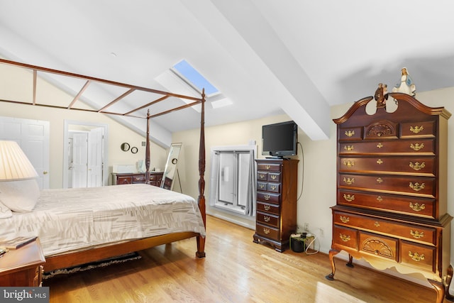 bedroom featuring a skylight and light hardwood / wood-style floors