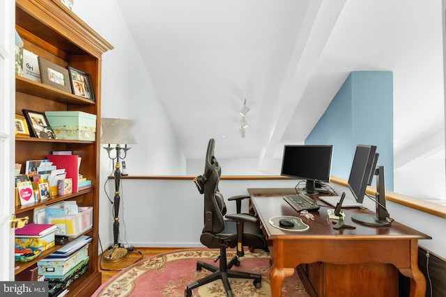 office area featuring wood-type flooring, rail lighting, and vaulted ceiling