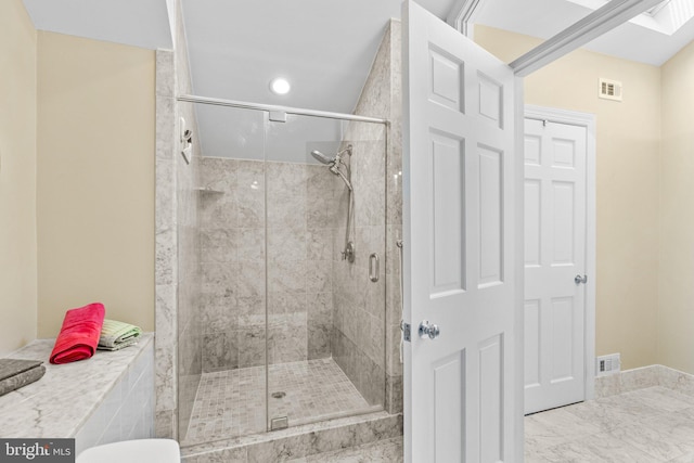 bathroom featuring a shower with shower door