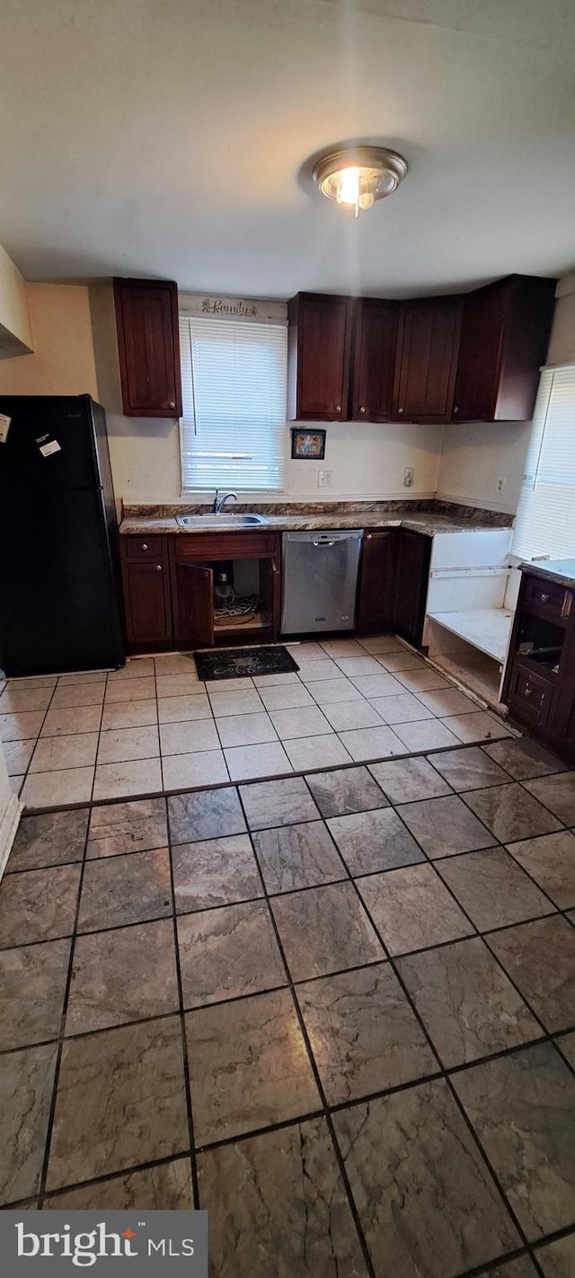 kitchen with black refrigerator, dark brown cabinetry, dishwasher, and sink