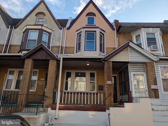 townhome / multi-family property featuring cooling unit and a porch