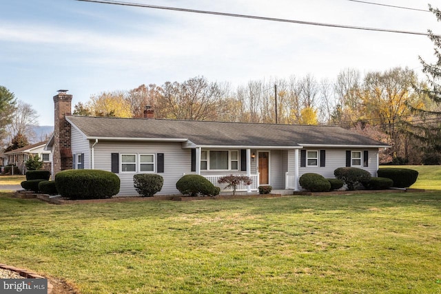 ranch-style home with covered porch and a front yard