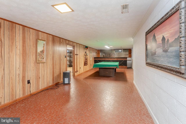 recreation room featuring wooden walls, a textured ceiling, and pool table