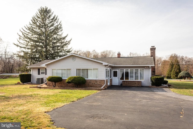 single story home with central AC unit and a front lawn