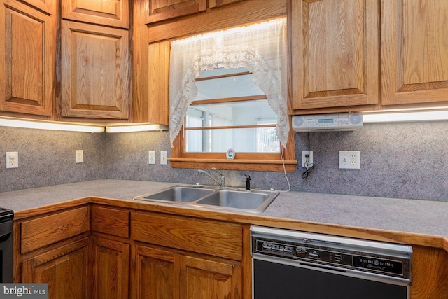 kitchen featuring dishwashing machine, tasteful backsplash, and sink