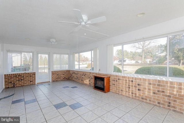 unfurnished sunroom featuring ceiling fan