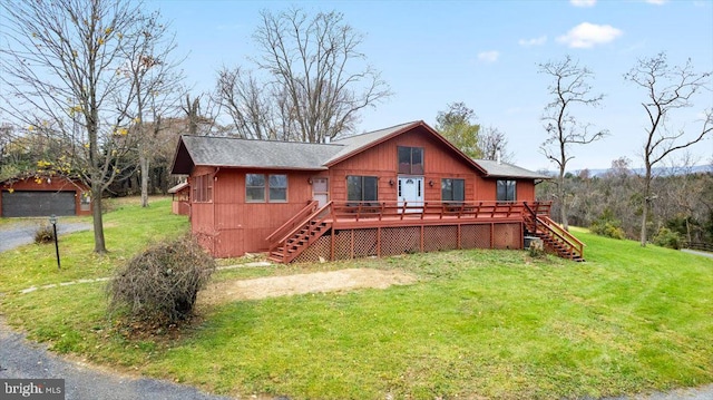 rear view of property featuring a yard and a wooden deck