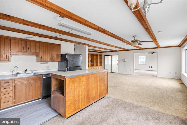 kitchen featuring beam ceiling, ceiling fan, sink, black refrigerator, and a kitchen island