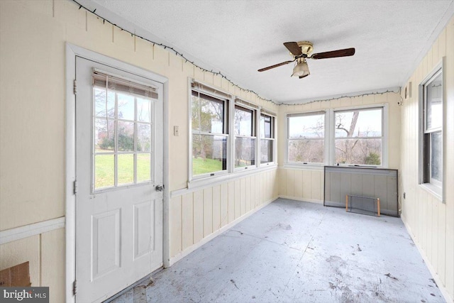 unfurnished sunroom with ceiling fan