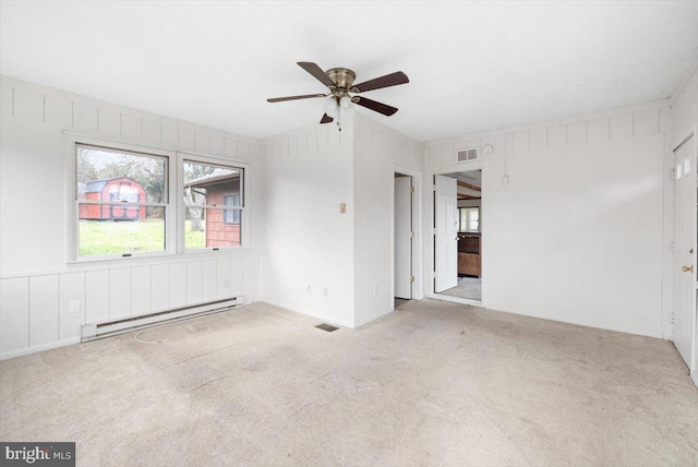 spare room with ceiling fan, light colored carpet, and a baseboard radiator