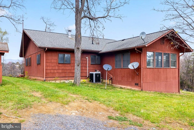 rear view of property featuring a yard and cooling unit