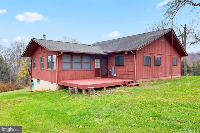 rear view of house featuring a lawn and a wooden deck