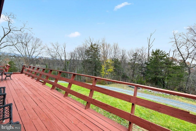 wooden terrace featuring a lawn