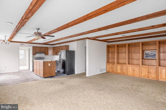 unfurnished living room featuring ceiling fan, beam ceiling, and light carpet