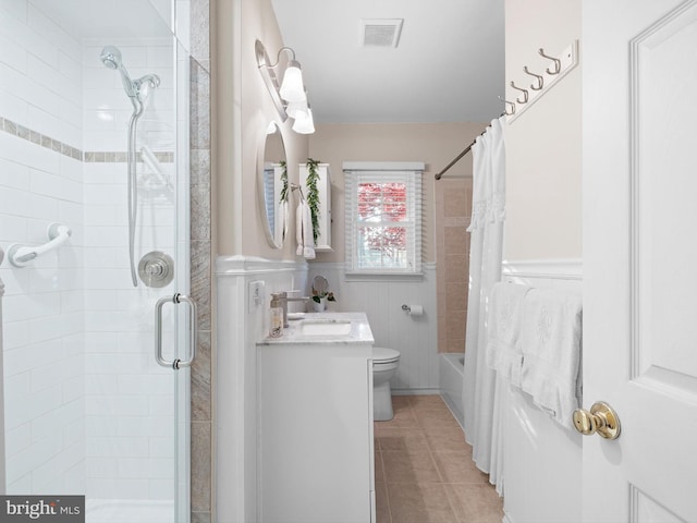 full bathroom featuring tile patterned floors, toilet, shower / bath combo with shower curtain, vanity, and tile walls