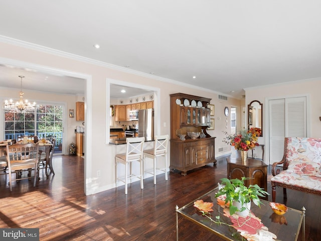 living room with a chandelier, ornamental molding, and dark wood-type flooring