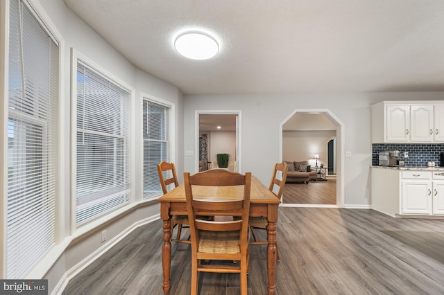 dining area with wood-type flooring and a textured ceiling