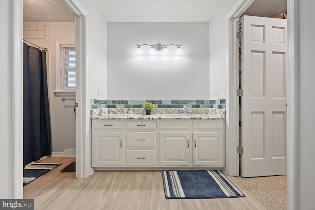 bathroom with vanity, hardwood / wood-style floors, and a textured ceiling