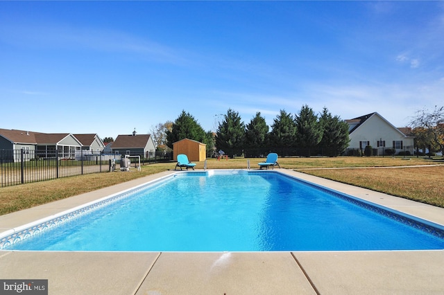 view of pool featuring a storage unit and a lawn