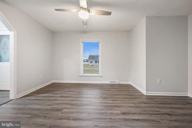 unfurnished room featuring a textured ceiling, ceiling fan, and dark wood-type flooring