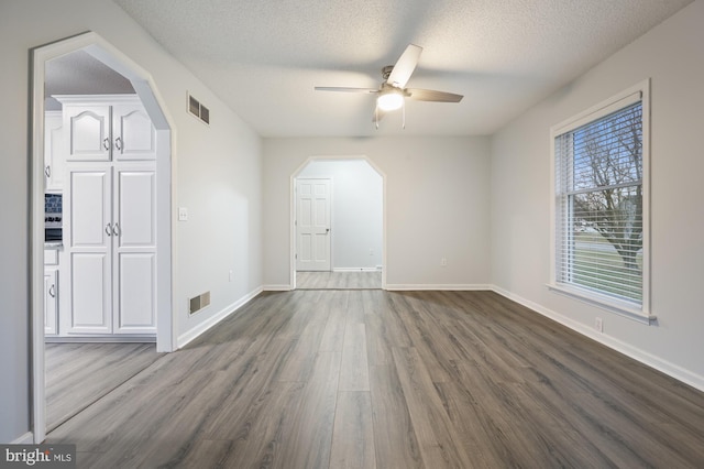 spare room featuring hardwood / wood-style flooring, ceiling fan, and a textured ceiling