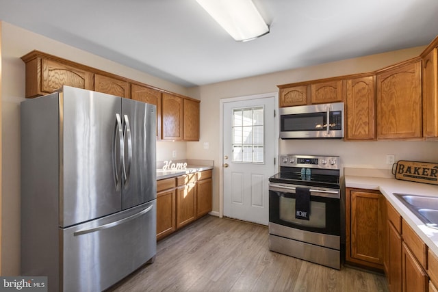 kitchen featuring sink, stainless steel appliances, and light wood-type flooring