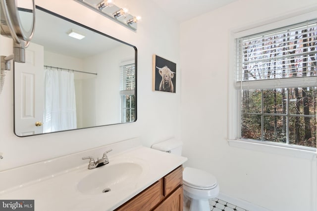 bathroom featuring tile patterned floors, vanity, curtained shower, and toilet