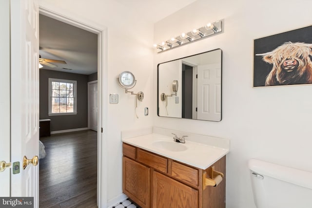 bathroom with ceiling fan, toilet, vanity, and hardwood / wood-style flooring