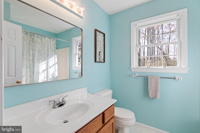 bathroom featuring tile patterned floors, vanity, toilet, and walk in shower