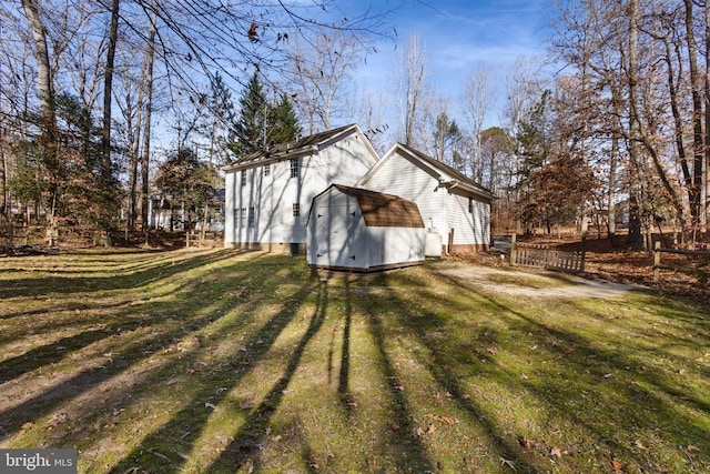 view of side of property featuring a yard and a storage shed