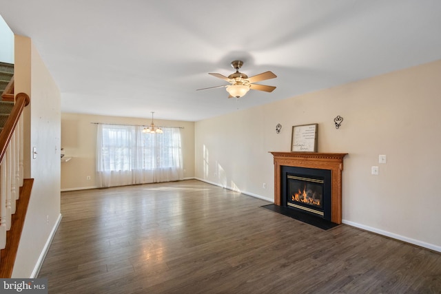 unfurnished living room featuring ceiling fan with notable chandelier and dark hardwood / wood-style flooring