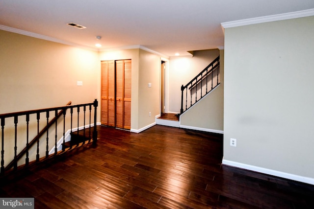 empty room with dark hardwood / wood-style floors and crown molding