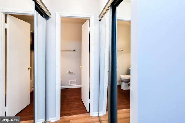 corridor with hardwood / wood-style flooring