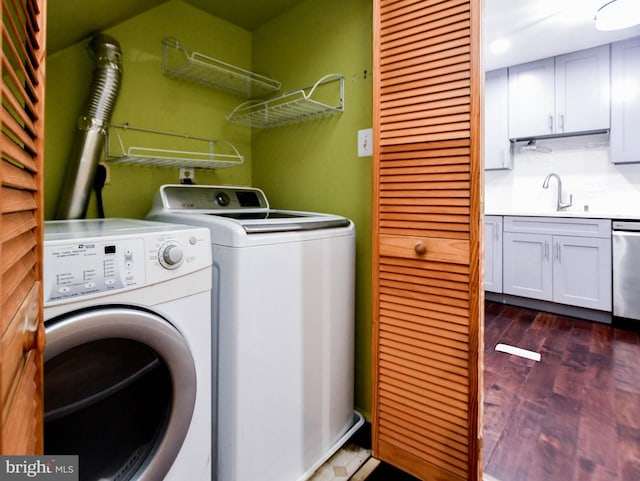 laundry area with washer and dryer, dark hardwood / wood-style floors, and sink