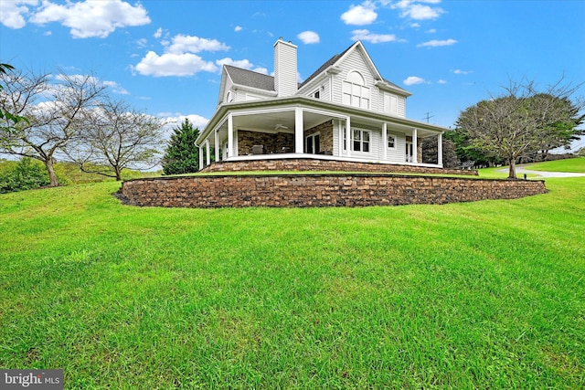 back of house featuring ceiling fan and a yard