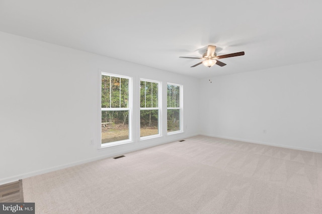 empty room featuring light colored carpet and ceiling fan