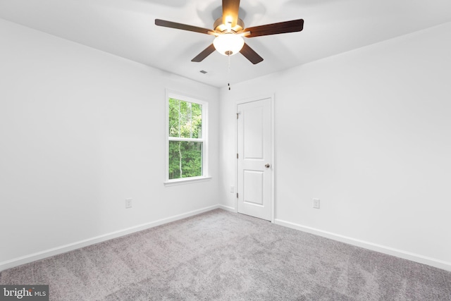 carpeted spare room featuring ceiling fan