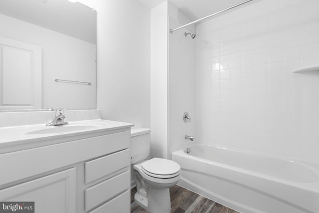 full bathroom with hardwood / wood-style floors, tiled shower / bath combo, toilet, and vanity