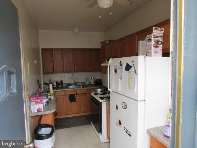 kitchen with decorative backsplash, white appliances, ceiling fan, exhaust hood, and sink