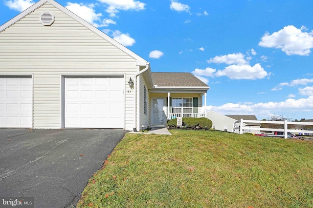 view of front facade featuring a front lawn, covered porch, and a garage